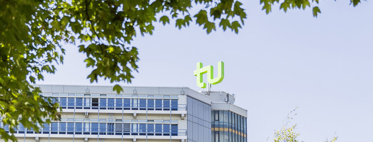 Mathetower mit TU-Logo umrahmt von Bäumen Mathetower mit TU-Logo umrahmt von Bäumen