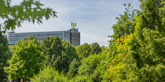 TU Dortmund in summer_01 The mathematics building with green trees in the foreground.
