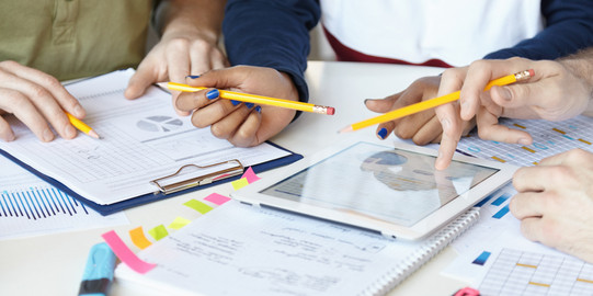 On a table are pads and sheets, a tray used by one hand.