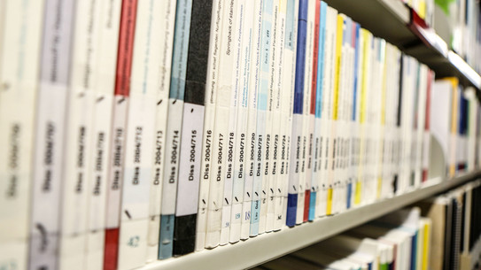 Dissertations in library Books with the inscription dissertation on a bookshelf in the library.